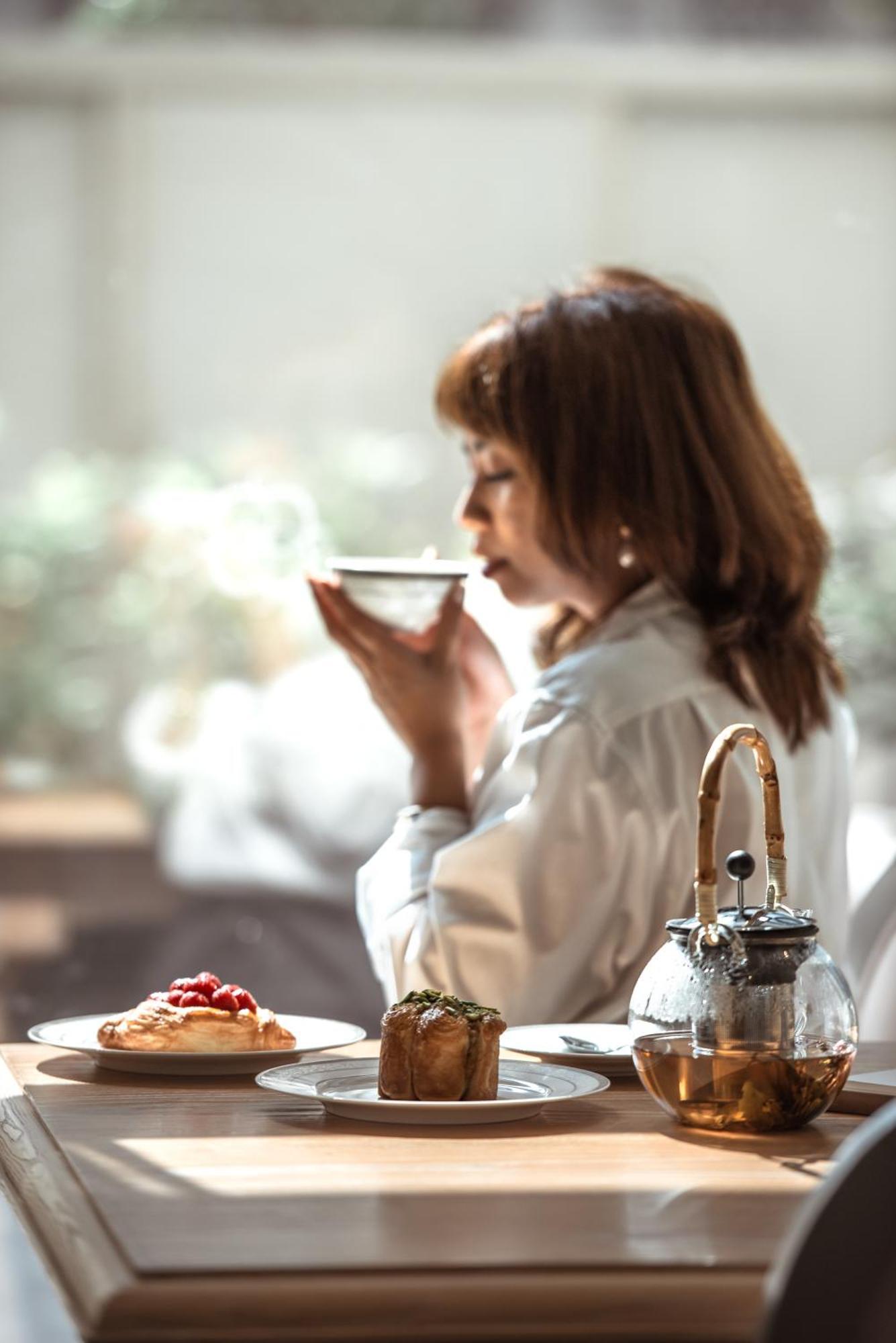 Dusit Doha Hotel Exterior foto A woman drinking tea