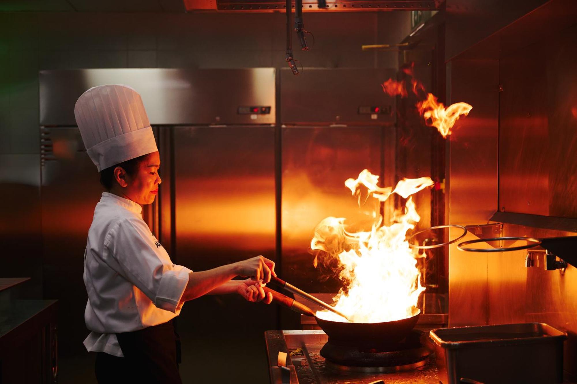 Dusit Doha Hotel Exterior foto A chef cooking with a wok
